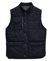 A black utility vest with a high collar, snap-button front closure, and quilted stitching. The vest features a zippered chest pocket with a flap, along with two large front flap pockets near the hem. Designed for durability and functionality, ideal for workwear or outdoor use. by MAK Boots & Garments