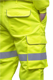 A person wearing high-visibility yellow work trousers with reflective grey stripes around the knees, shins, and thighs. The pants have a cargo pocket on the side and are paired with black safety boots. Only the lower half of the person is visible. The trousers appear to be part of a workwear or safety uniform. by MAK Boots & Garments