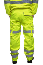 A person wearing high-visibility yellow work trousers with reflective grey stripes around the knees, shins, and thighs. The pants have a cargo pocket on the side and are paired with black safety boots. Only the lower half of the person is visible. The trousers appear to be part of a workwear or safety uniform. by MAK Boots & Garments