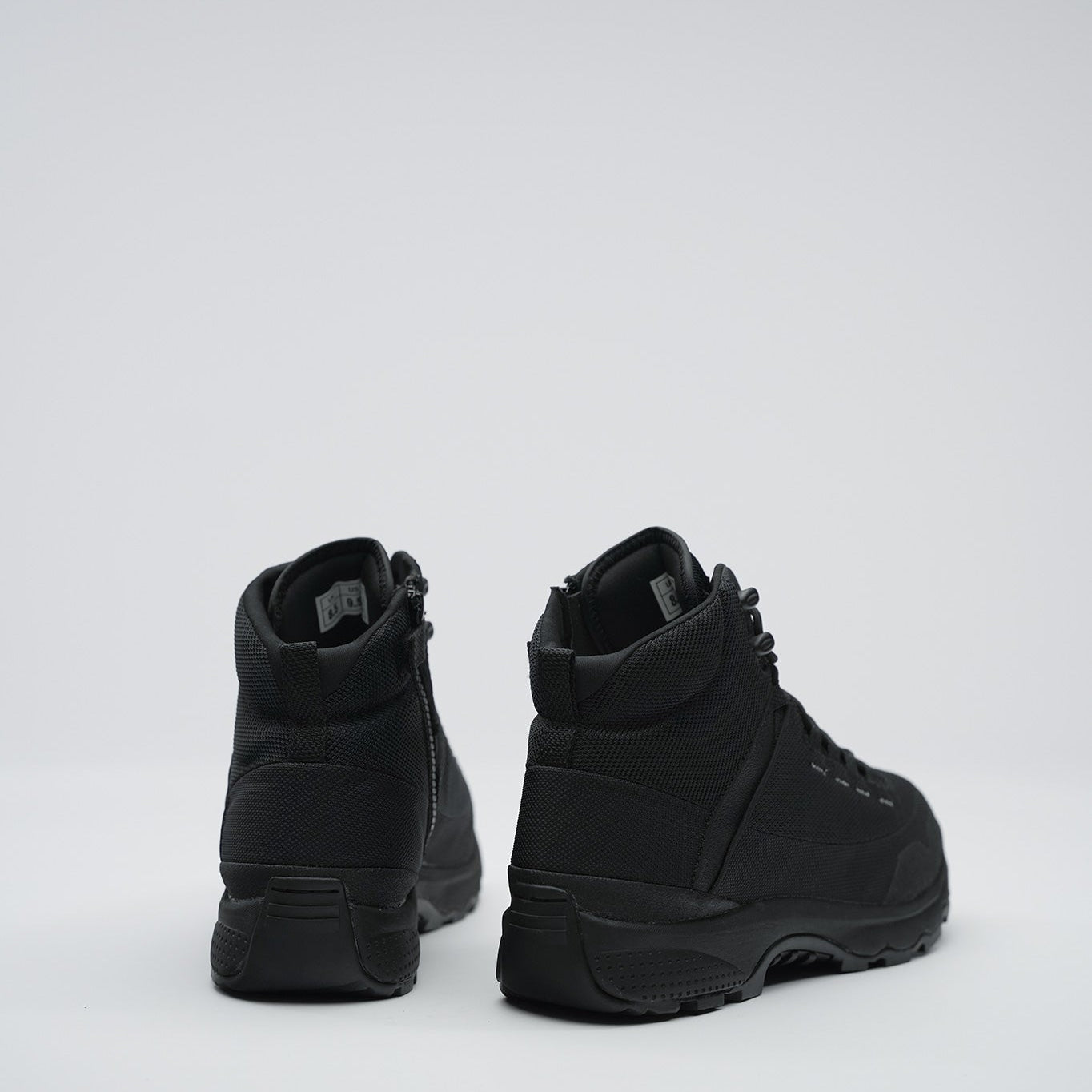 Pair of black high-top sneakers on a white background