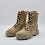 A pair of tan tactical combat boots with laces, shown on a light gray studio background.