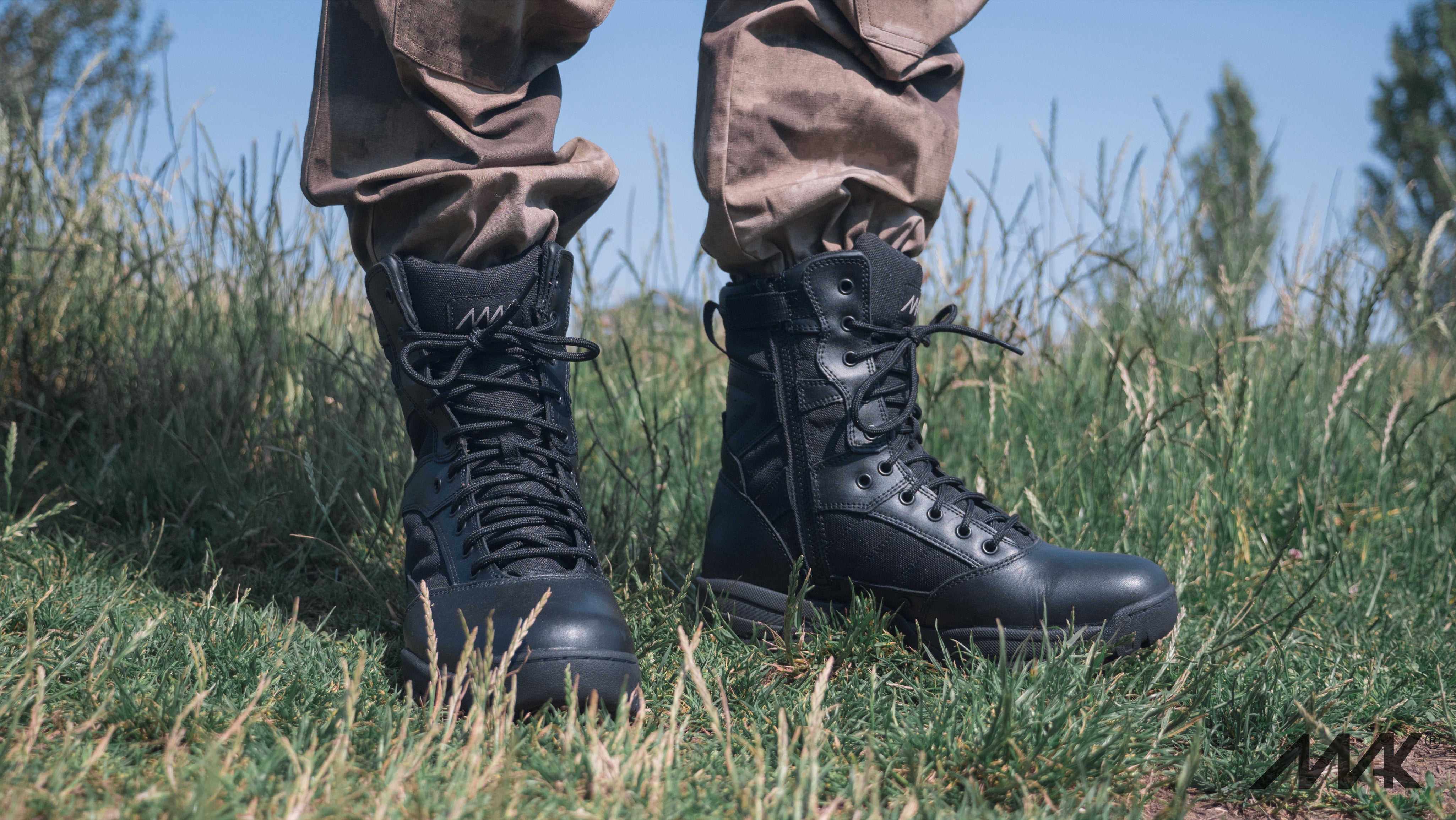 black leather military boot in black leather in grass